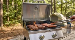 Sizzling burger patties and hot dogs cooking on a dual-burner tabletop gas grill