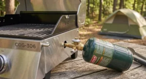 Close-up illustration showing a portable tabletop gas grill connected to a standard 1lb green propane tank