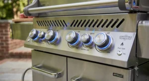 Close-up of LED-lit burner control knobs on a convertible natural gas grill