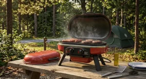 Dual burner portable propane camping grill featuring heat control knobs and a stainless steel cooking grate.