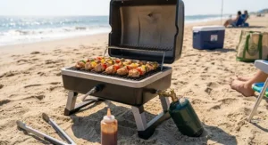 Close-up of a portable beach gas grill connected to a small green 1 lb propane canister