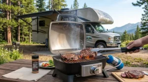 Steaks searing on a portable infrared grill set up outside a Class C motorhome in a state park.