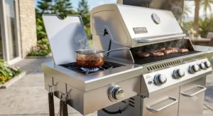 Close-up of a side burner on a propane gas grill simmering barbecue sauce in a saucepan